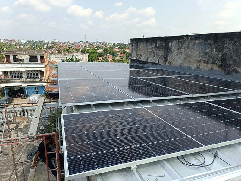 Tim teknisi memasang panel tenaga surya 1000 watt di atap rumah